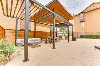 A patio with a white couch and a table under a roof.